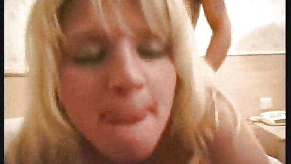 قدرتی چھاتی کے ساتھ ایک سنہرے بالوں والی لڑکی باغ میں ہے، اس کے پیروں کو پیار کر رہی ہے۔